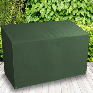 All-weather Bench Cover - 2 Seat, Green - placed in a garden on grass with plants behind 