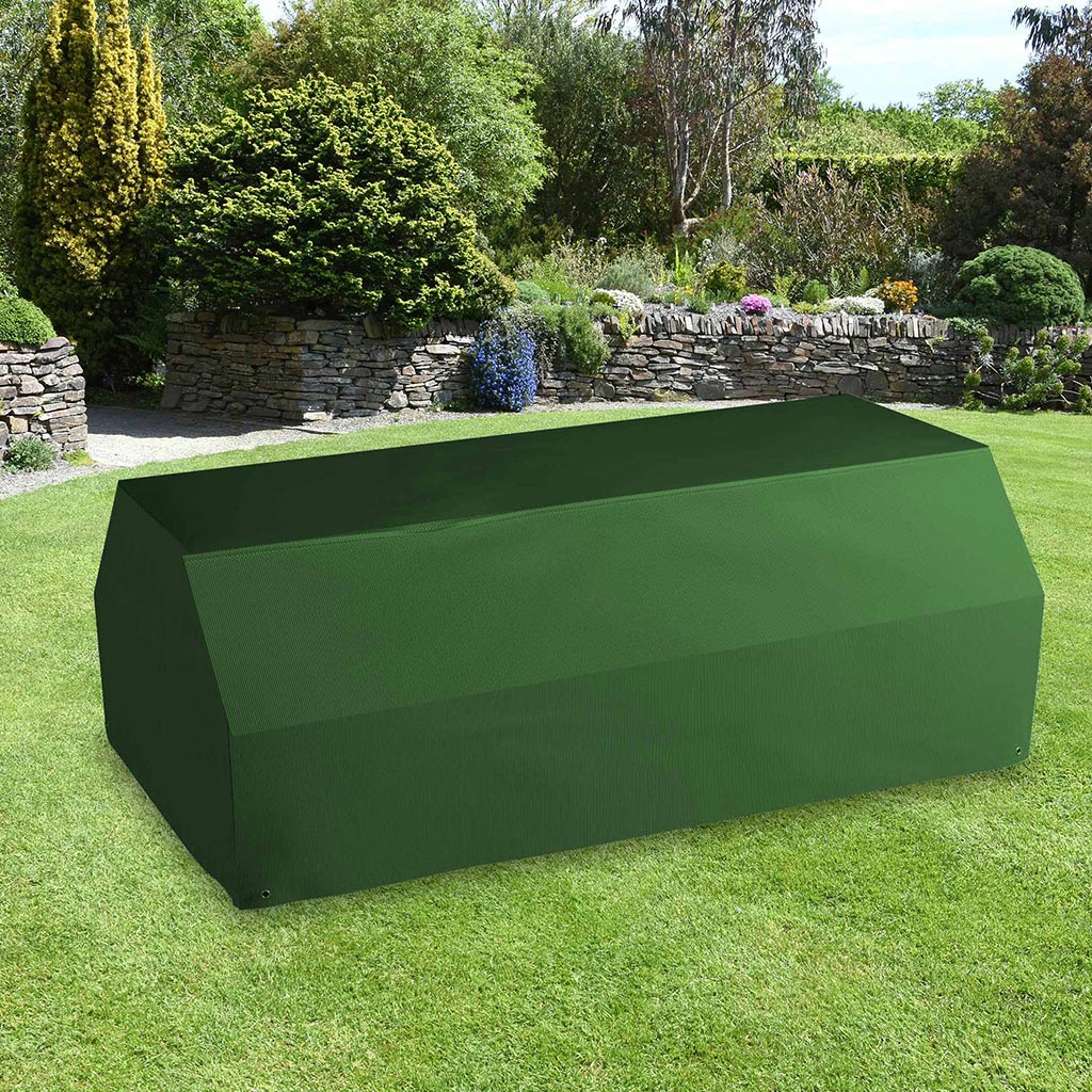 All-weather Picnic Table & Bench Cover placed in a garden on grass with plants behind