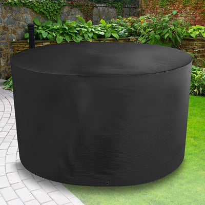 Bosmere All-Weather Circular Table Cover - 4/6 Seat Black placed in a garden on grass with plants behind 