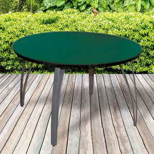All-weather Round Table Top Cover placed in a garden on grass with plants behind 